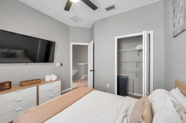 a bedroom with a bed and a flat tv screen on wall