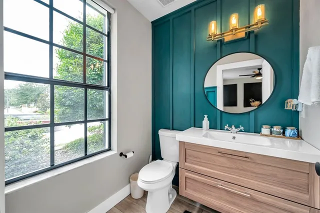 a bathroom with a toilet sink and mirror