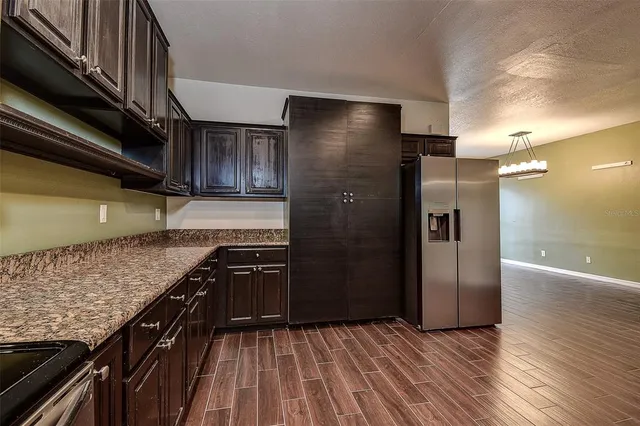 a kitchen with stainless steel appliances granite countertop a refrigerator and a sink
