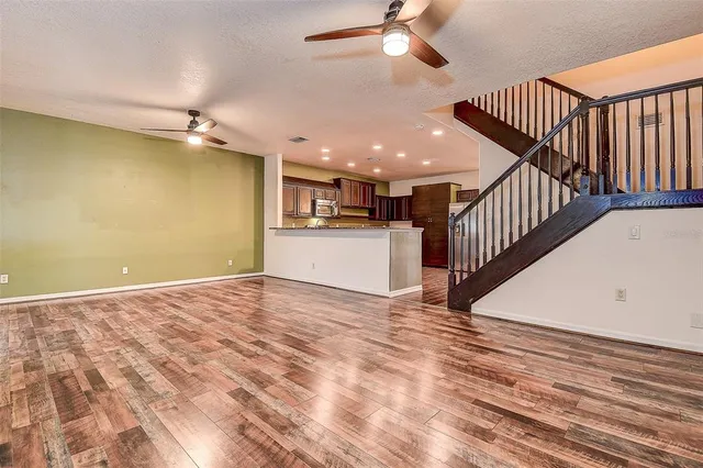 a view of a livingroom with wooden floor and staircase