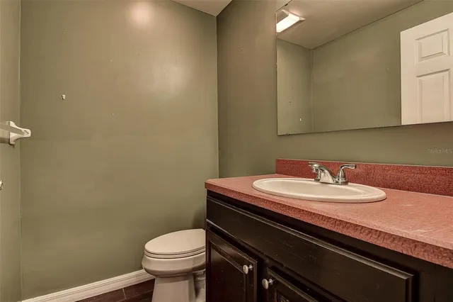 a bathroom with a granite countertop toilet and a sink