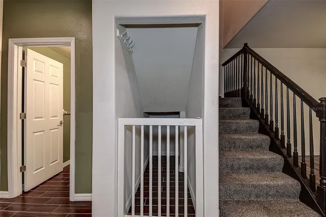 a view of a hallway with wooden floor and staircase