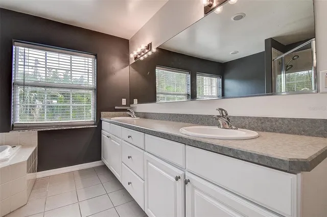 a bathroom with a granite countertop sink and a large mirror