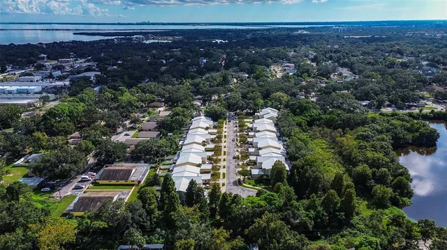an aerial view of residential houses with outdoor space and trees