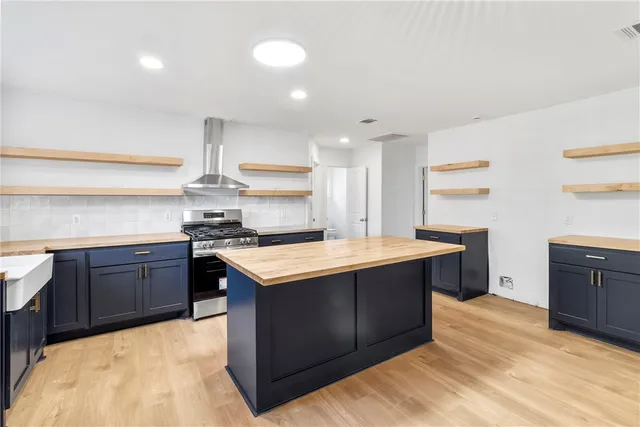 a large kitchen with stainless steel appliances granite countertop a sink counter space and wooden floor