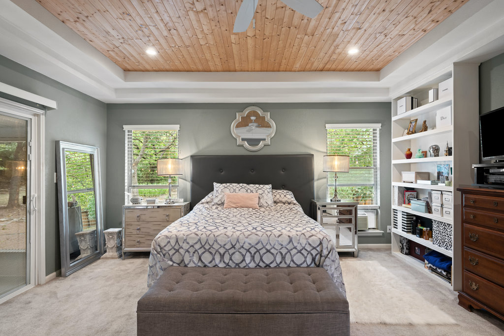 1709 Crested Butte Drive Austin, TX 78746 - Photo 11 of 40 a bedroom with a bed and a television