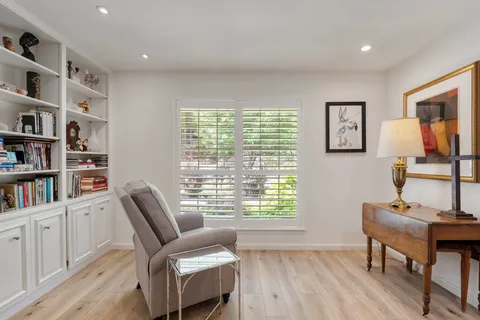 a view of a workspace with furniture and a window