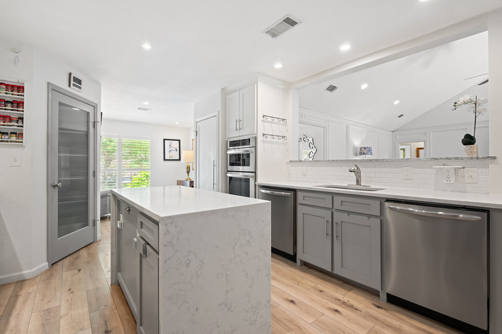 1709 Crested Butte Drive Austin, TX 78746 - Photo 21 of 40 a kitchen with counter top space sink and center island