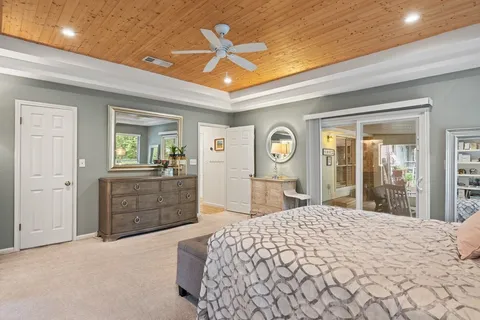 a bedroom with a large bed and dresser with mirror