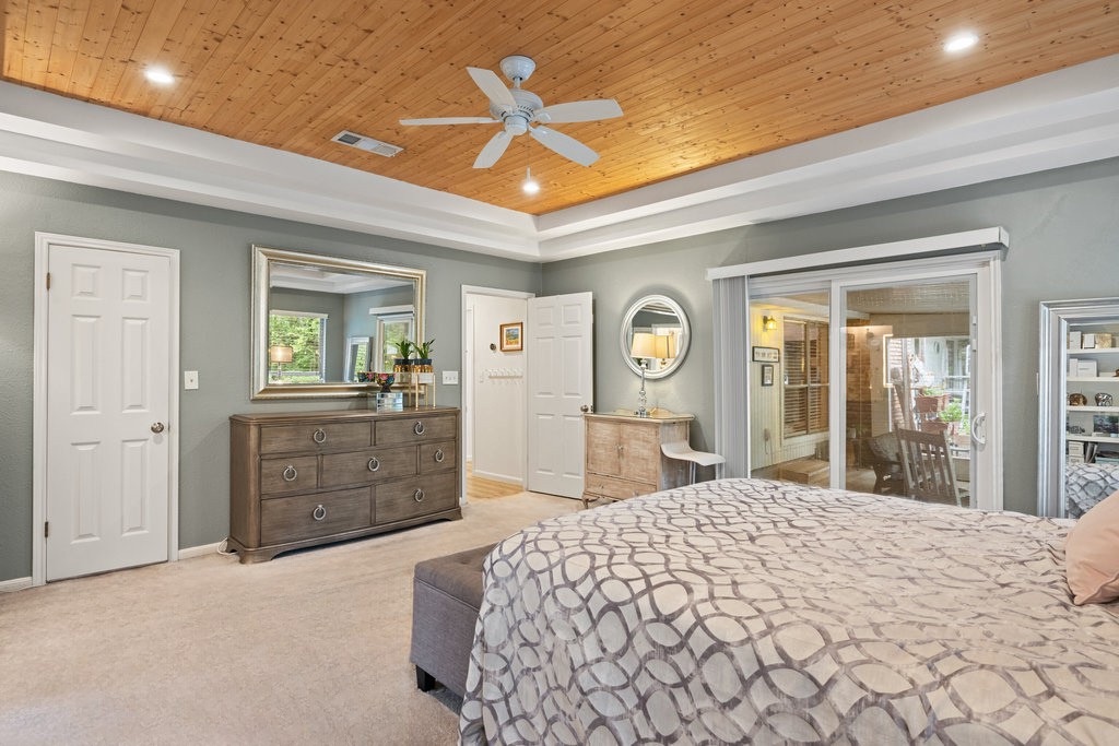 1709 Crested Butte Drive Austin, TX 78746 - Photo 27 of 40 a bedroom with a large bed and dresser with mirror