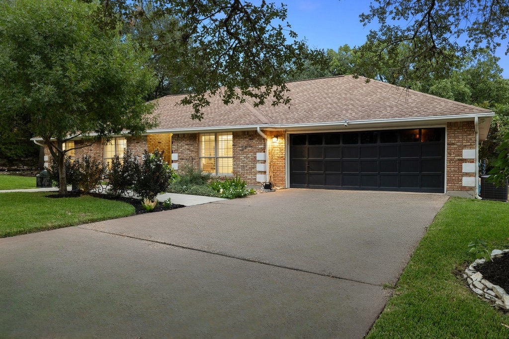 1709 Crested Butte Drive Austin, TX 78746 - Photo 3 of 40 a front view of a house with a yard and garage