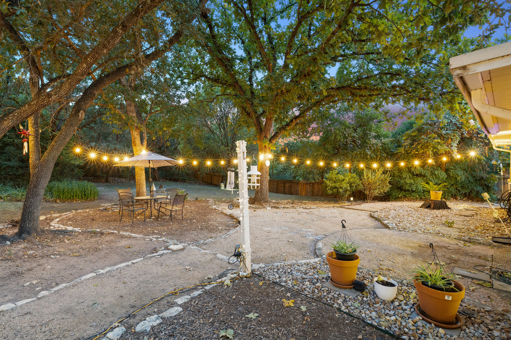 1709 Crested Butte Drive Austin, TX 78746 - Photo 40 of 40 a backyard of a house with fountain table and chairs