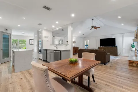 a kitchen with stainless steel appliances kitchen island granite countertop a table chairs microwave and sink