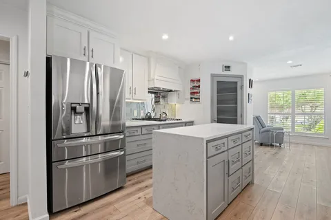 a kitchen with kitchen island white cabinets and stainless steel appliances
