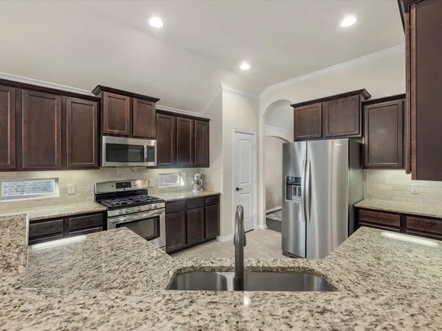 a kitchen with stainless steel appliances granite countertop a sink and cabinets