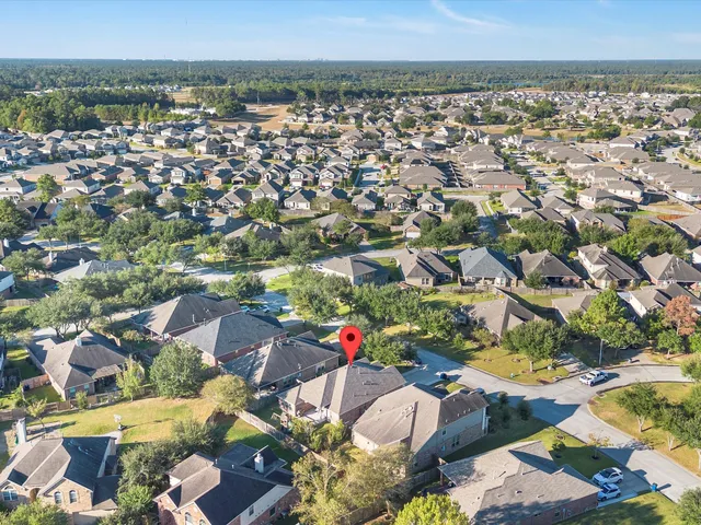 an aerial view of residential houses with outdoor space and trees