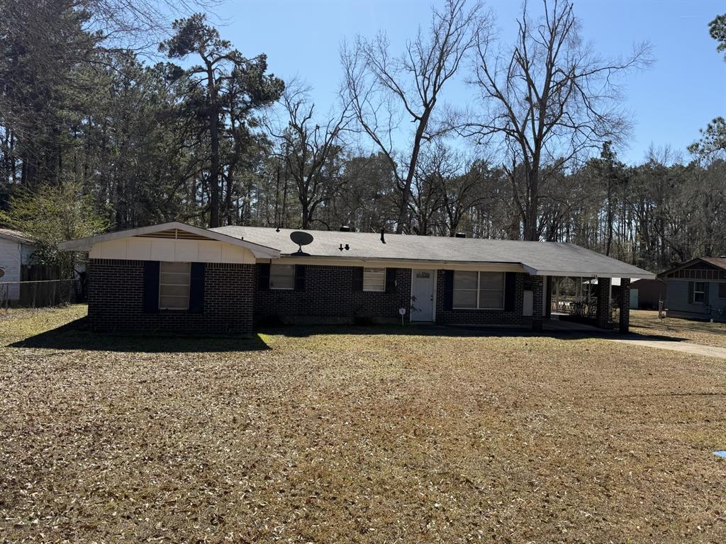 Single story home with brick siding and a carport