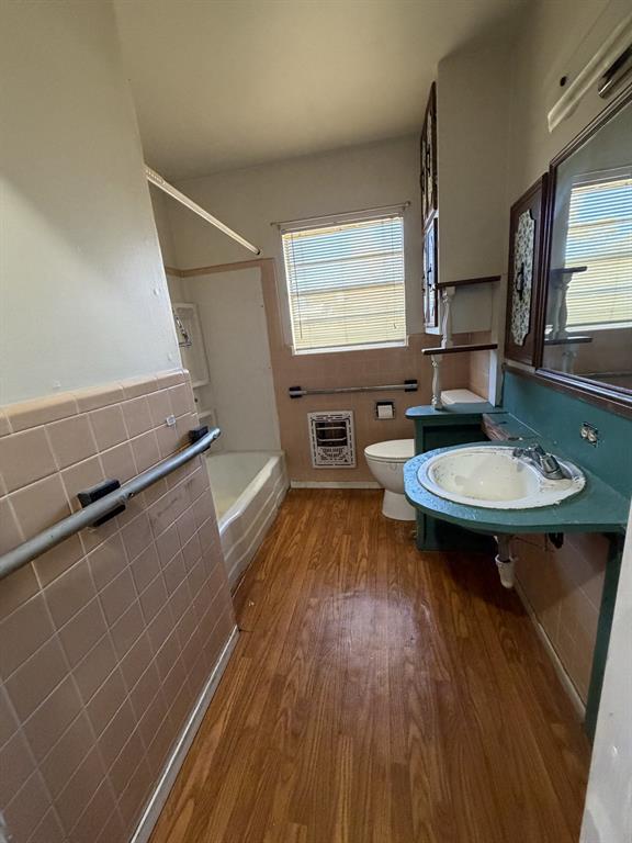 134 Hope Street Mansfield, LA 71052 - Photo 14 of 23 Bathroom 1 with tile walls, bathing tub / shower combination, wood finished floors, heating unit, and wainscoting