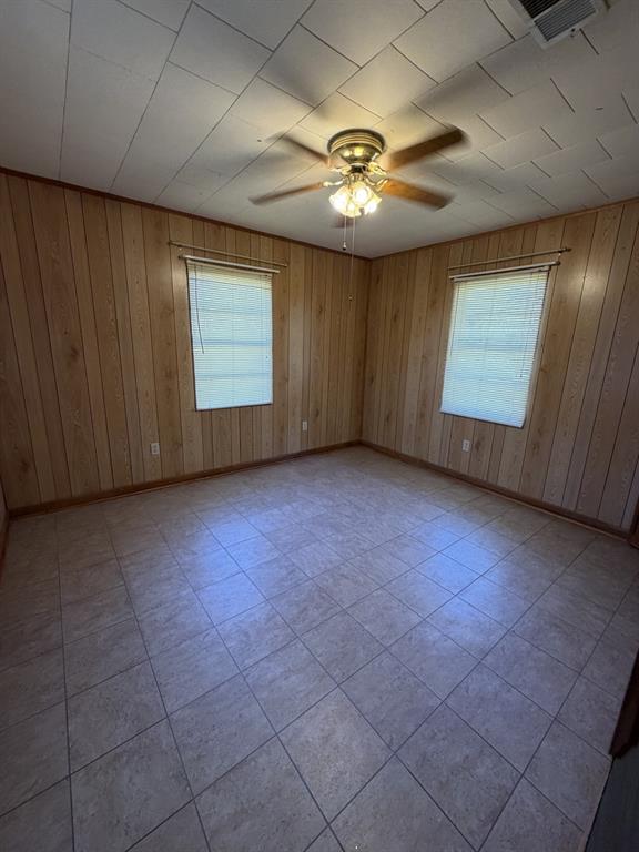 134 Hope Street Mansfield, LA 71052 - Photo 18 of 23 Bedroom 3 featuring wood walls, ceiling fan, and light tile patterned floors