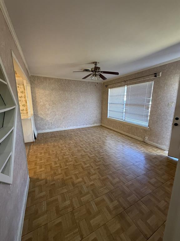 134 Hope Street Mansfield, LA 71052 - Photo 10 of 23 Living room view from hallway with ornamental molding, parquet floors, ceiling fan, and wallpapered walls