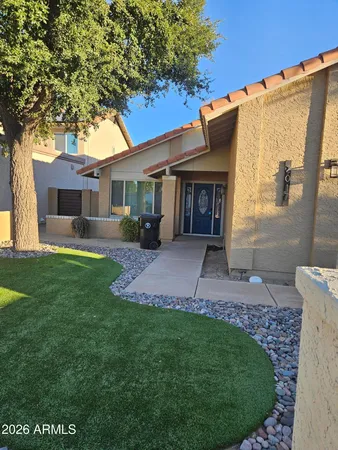 a front view of a house with a garden and yard