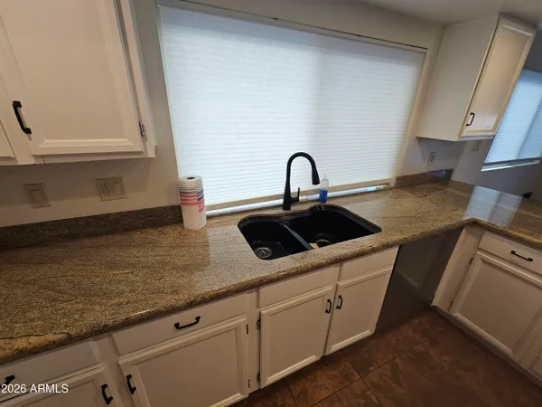a kitchen with stainless steel appliances granite countertop a sink a stove and cabinets