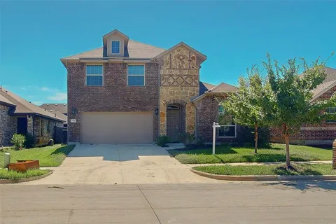 a front view of a house with a yard and potted plants