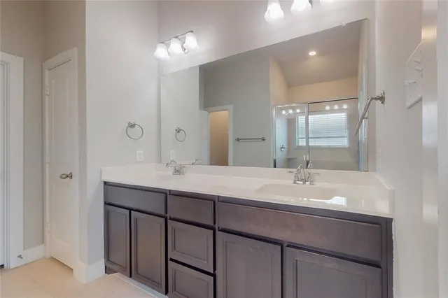 a bathroom with a double vanity sink and a mirror