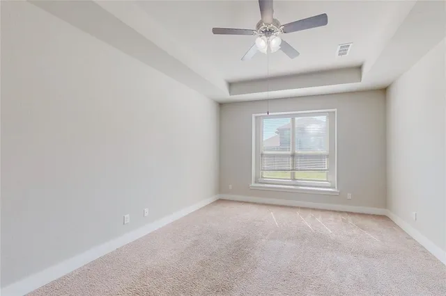 an empty room with a window and a fan