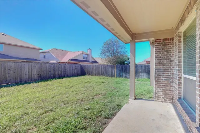 a view of a backyard with wooden fence