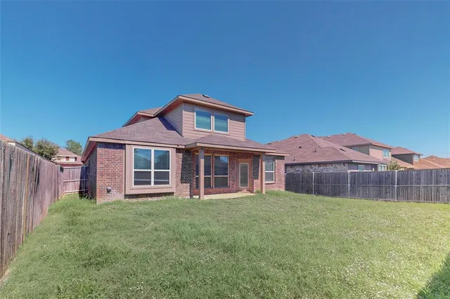 a view of a house with a yard and a large tree