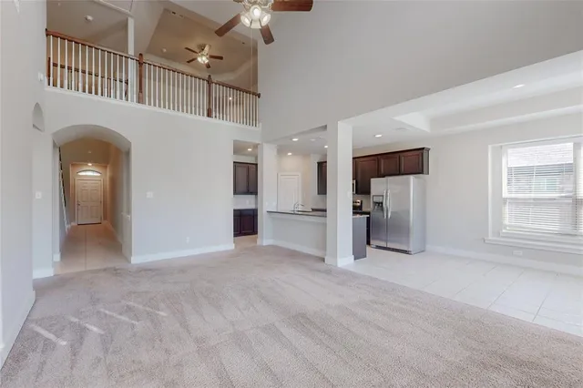 a view of empty room with a kitchen and refrigerator