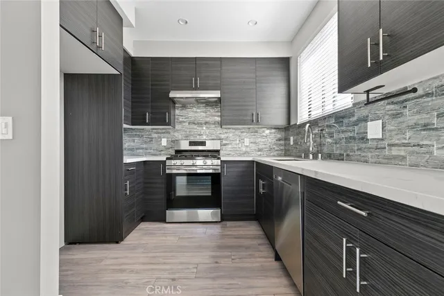 a kitchen with stainless steel appliances a stove and cabinets