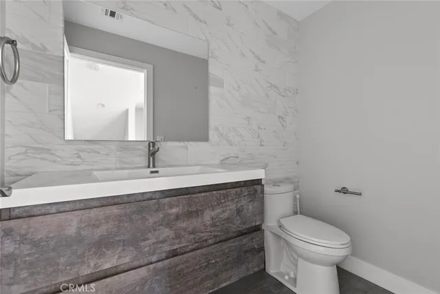 a bathroom with a sink a toilet and mirror