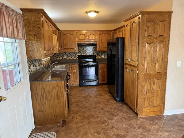 a view of kitchen with stainless steel appliances granite countertop cabinets and a refrigerator