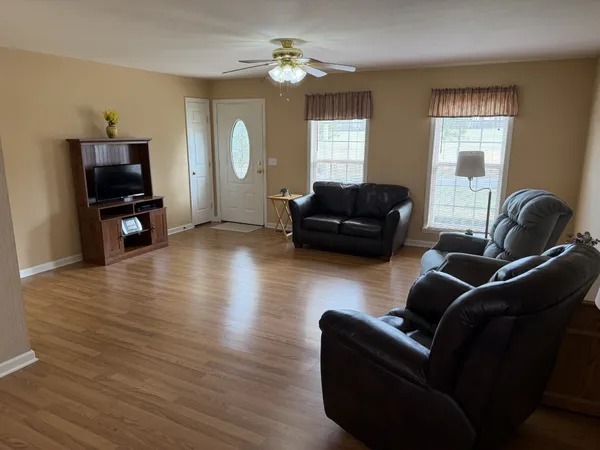 a living room with furniture and a wooden floor