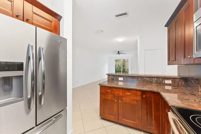a kitchen with stainless steel appliances granite countertop a refrigerator and a sink