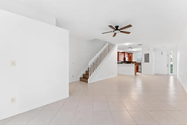 an empty room with ceiling fan and entryway