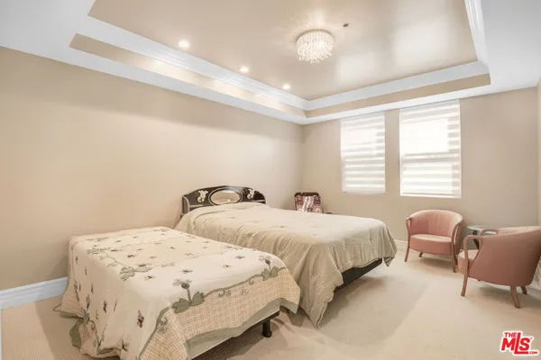 a bedroom with two beds and a chair