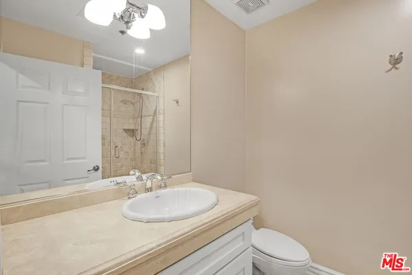 a bathroom with a toilet a sink and a mirror