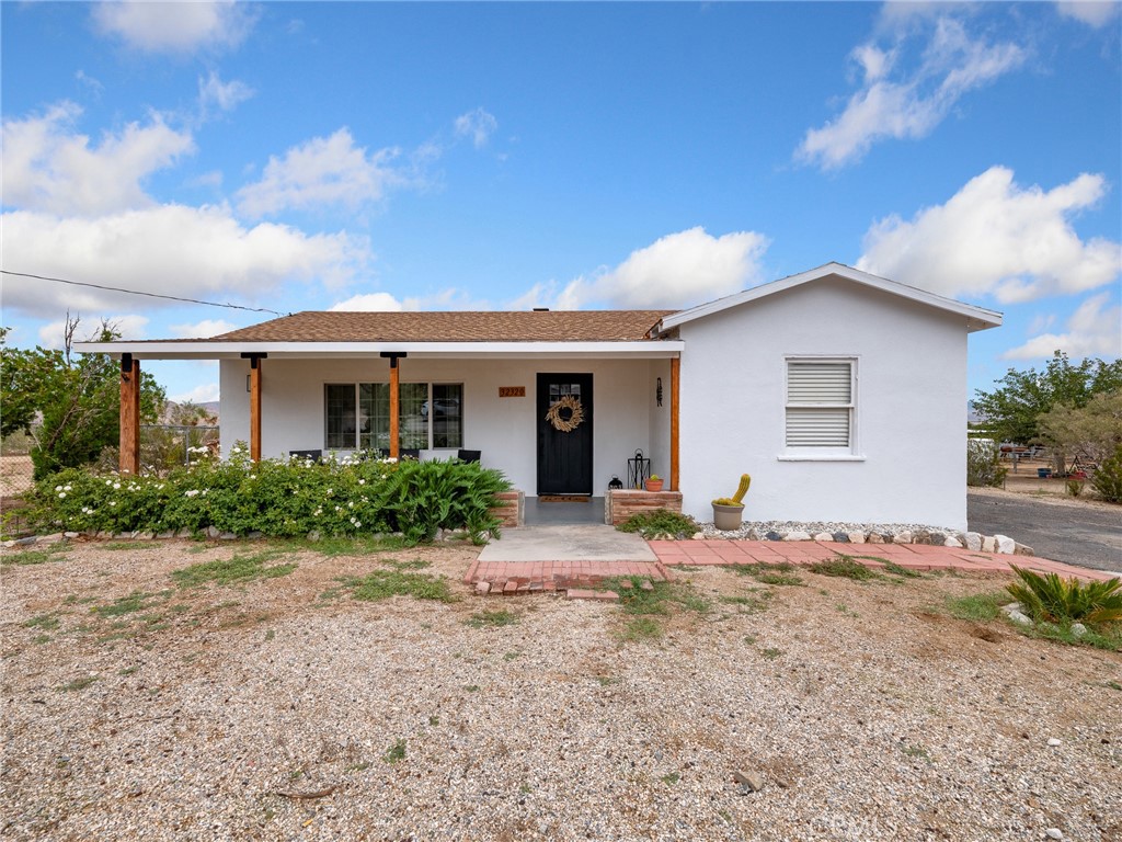 a front view of house with yard and trees in the background