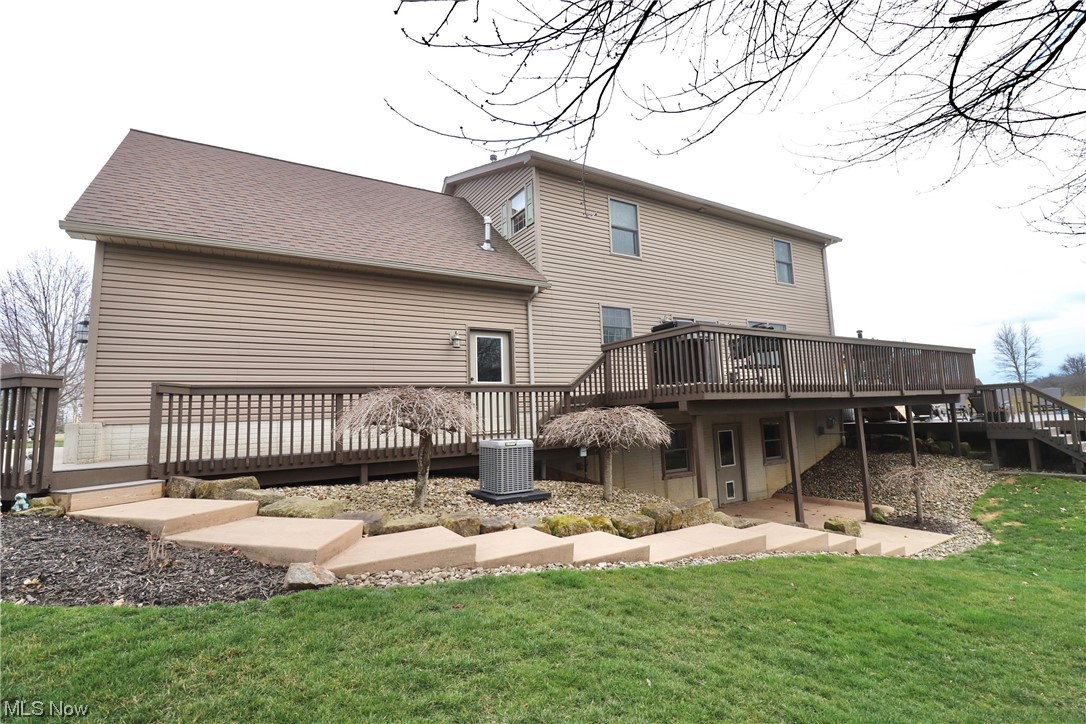 10582 Irvin Road Creston, OH 44217 - Photo 40 of 47 Back of property with a deck, a lawn, and central AC
