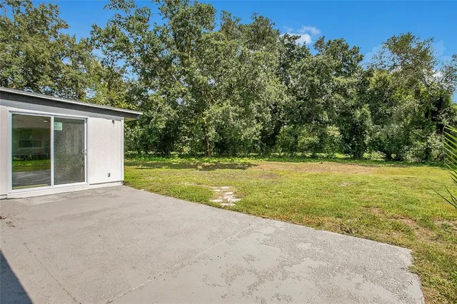 a view of a house with a yard and basketball court