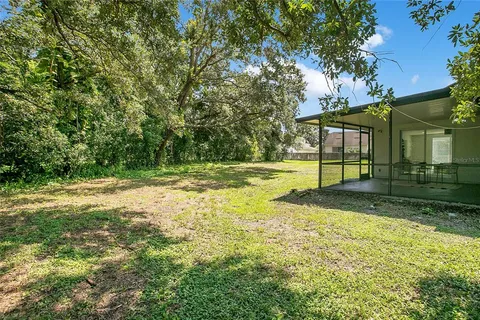 a view of a house with backyard and tree