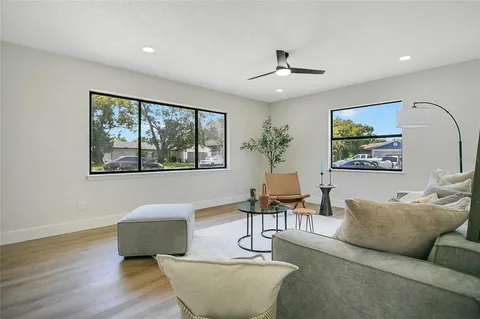 a living room with furniture a window and wooden floor