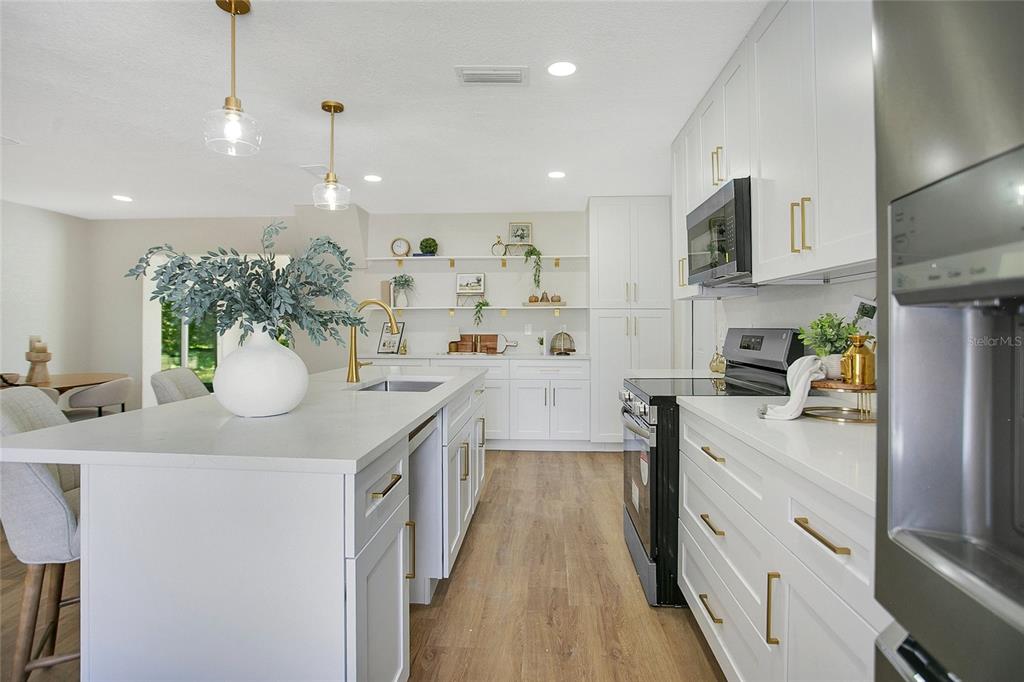 1914 Bonanza Court Winter Park, FL 32792 - Photo 8 of 33 a kitchen with a sink dishwasher stove and white cabinets with wooden floor