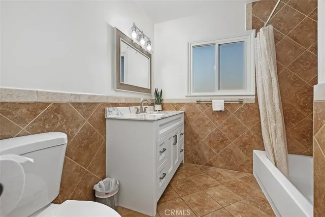 a spacious bathroom with a sink a toilet a mirror and bathtub