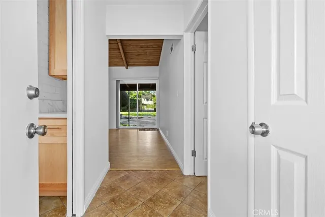 a view of a hallway with wooden floor and a living room
