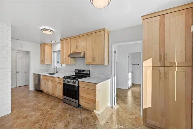 a kitchen with a stove a refrigerator and a sink