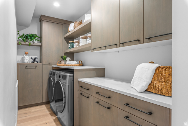 1258 Rothwell Road Park City, UT 84060 - Photo 23 of 48 Dedicated laundry space featuring stacked appliances, extensive cabinetry with dark hardware, open shelving, white countertops, and wood-finish flooring